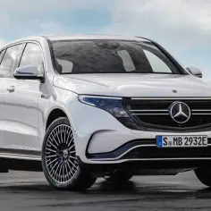 Biały Mercedes EQC, elektryczny SUV, prezentuje się elegancko na tle błękitnego nieba.
