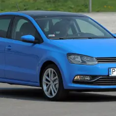 Niebieski Volkswagen Polo 6R z czarnym dachem i kierowcą za kierownicą.