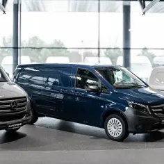 Trzy dostawcze samochody marki Mercedes-Benz: szary, granatowy i biały, stoją w salonie.
