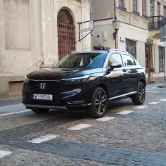 Ciemny Honda HR-V na brukowanej ulicy starego miasta.