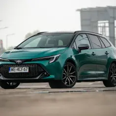 Zielona Toyota Corolla GR Sport z czarnym dachem i felgami, zaparkowana na mokrym asfalcie.