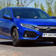Błękitny Honda Civic 2017 z polskimi tablicami rejestracyjnymi jedzie po drodze.