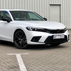 Biały Honda Civic 2025 z czarnymi felgami stoi na parkingu.