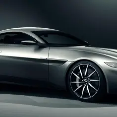 Srebrny Aston Martin DB10, sportowy samochód o aerodynamicznej sylwetce, prezentuje swoje eleganckie linie i felgi.