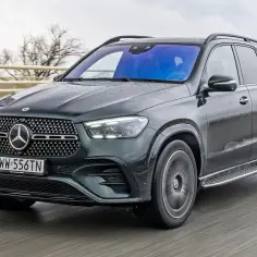 Ciemnozielony Mercedes GLE 2025 w deszczu, jadący po moście.