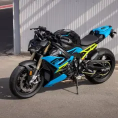 Czarny motocykl BMW S1000R z neonowożółtym stelażem i niebieskimi akcentami stoi na asfalcie.
