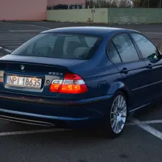 Granatowe BMW E46 330d na parkingu. Wiele pozytywnych bmw e46 330d opinie potwierdza jego klasę.