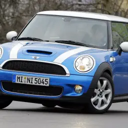 Niebieski Mini Cooper z białymi pasami na masce. Wiele osób chwali sobie jego zwinność, co potwierdzają liczne mini cooper opinie.