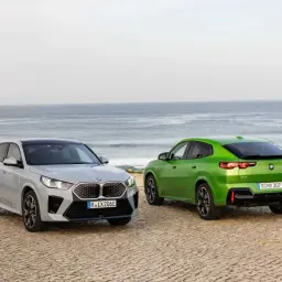 Dwa BMW X2, srebrne i zielone, stoją nad morzem. Poznaj ich wymiary i możliwości.