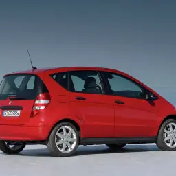 Czerwony Mercedes A170 na tle bezkresnego nieba i wody.