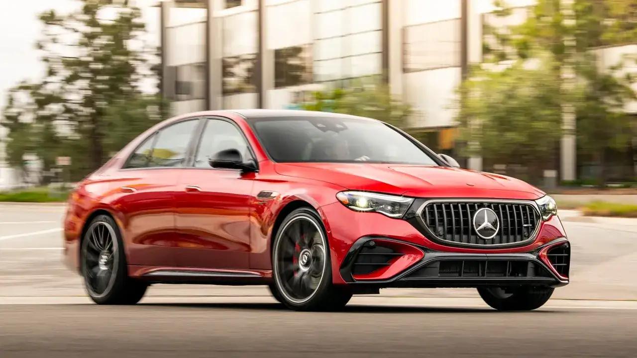 Czerwony Mercedes-AMG E53 pędzi ulicą, jego sportowy design przyciąga wzrok.