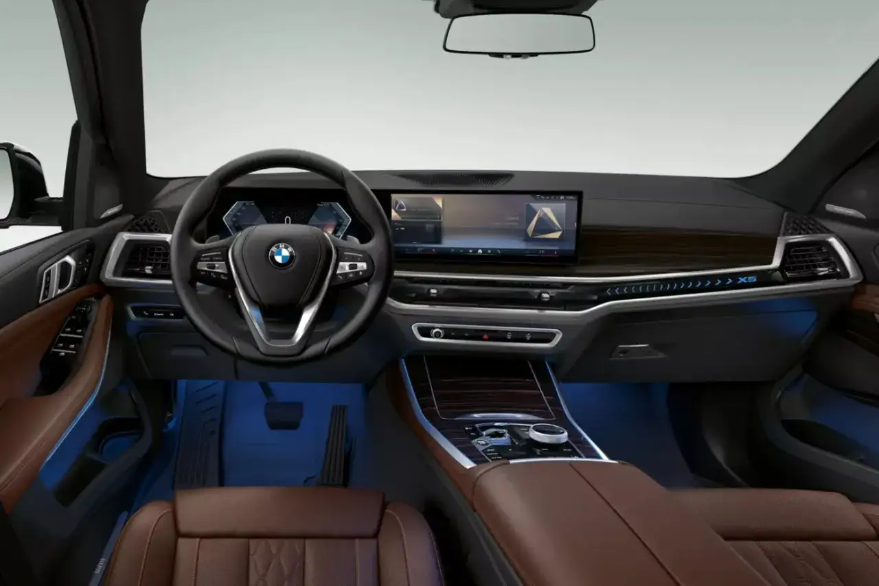 Wnętrze BMW X5 2024: skórzana tapicerka, nowoczesny kokpit z dużym ekranem i ambientowe oświetlenie.