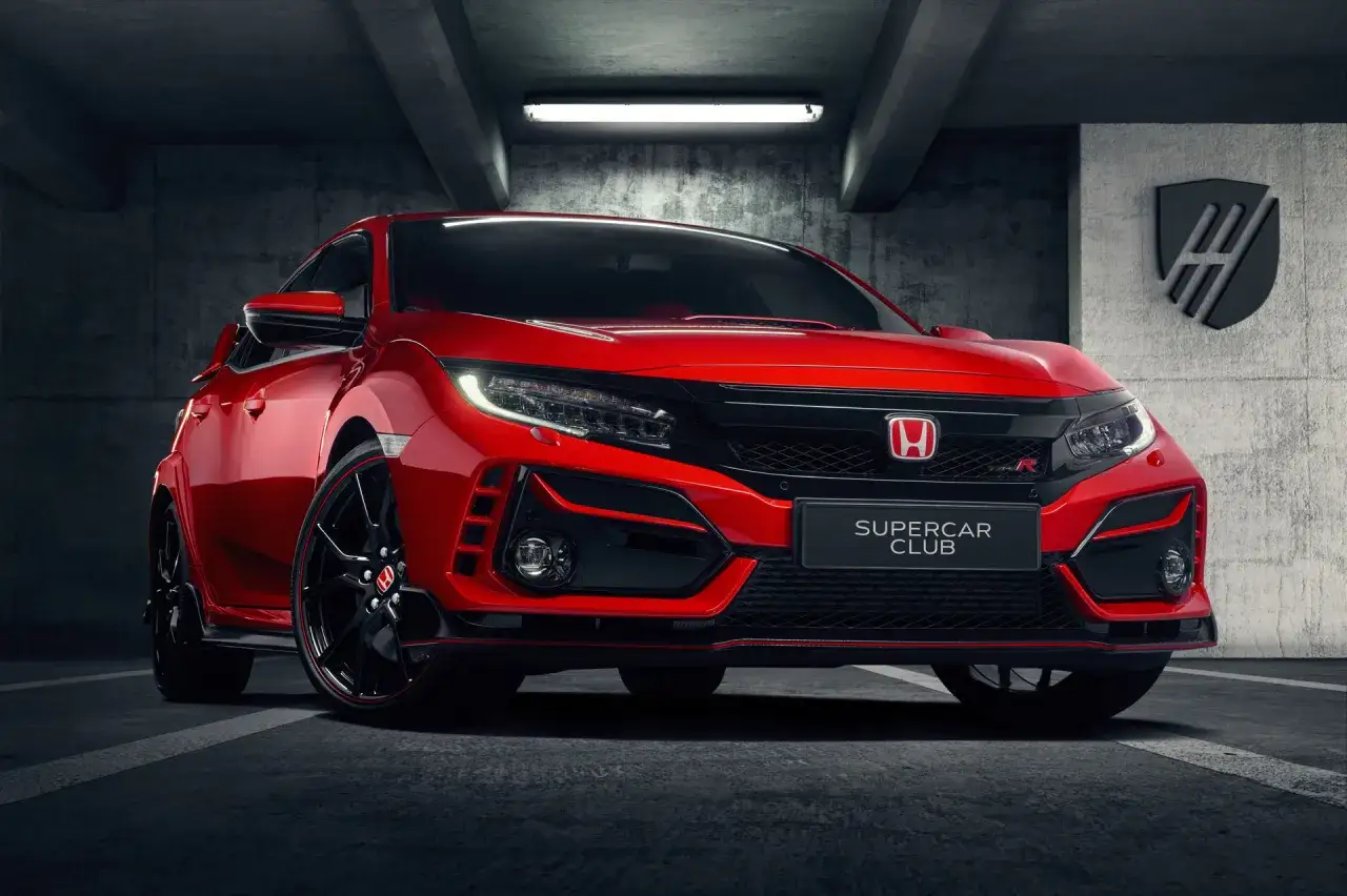 Czerwony Honda Civic Type R z czarnymi felgami i czerwonymi akcentami, zaparkowany w garażu.