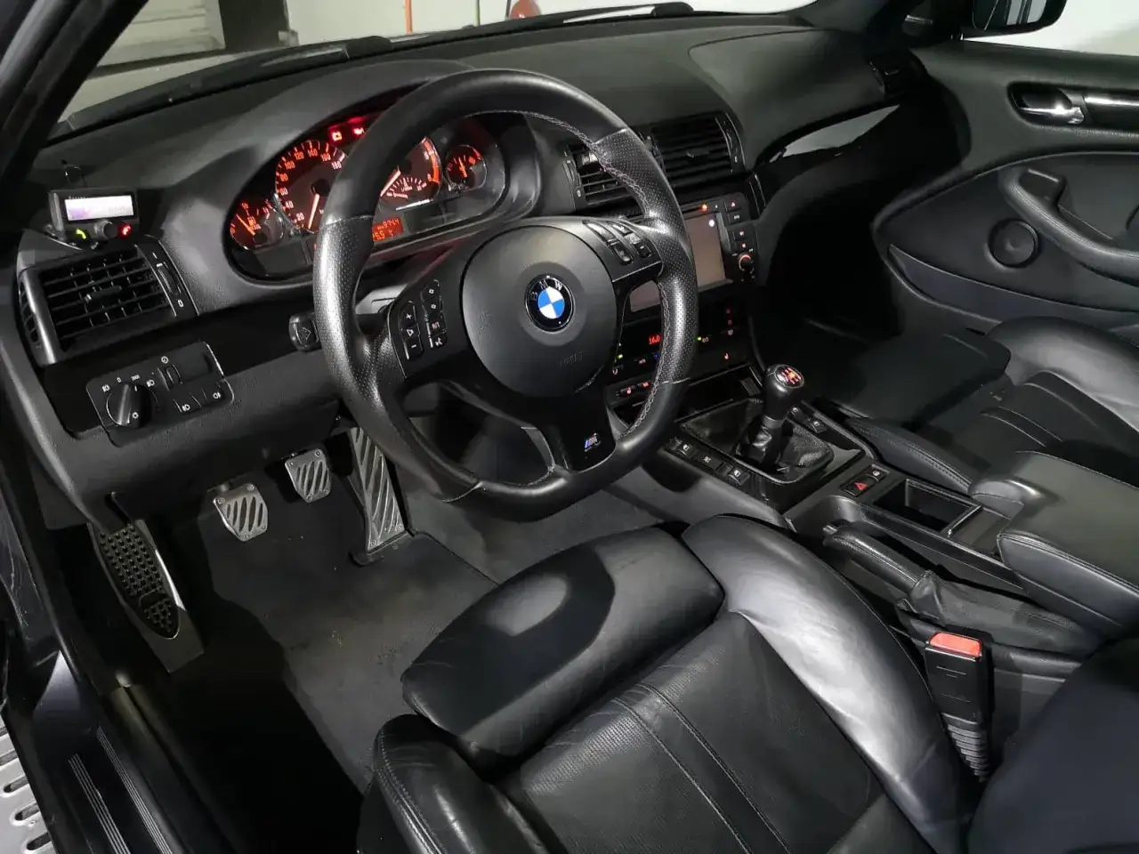 Wnętrze BMW E46 330d. Skórzana tapicerka, sportowa kierownica i manualna skrzynia biegów. Opinie o tym modelu są zazwyczaj pozytywne.