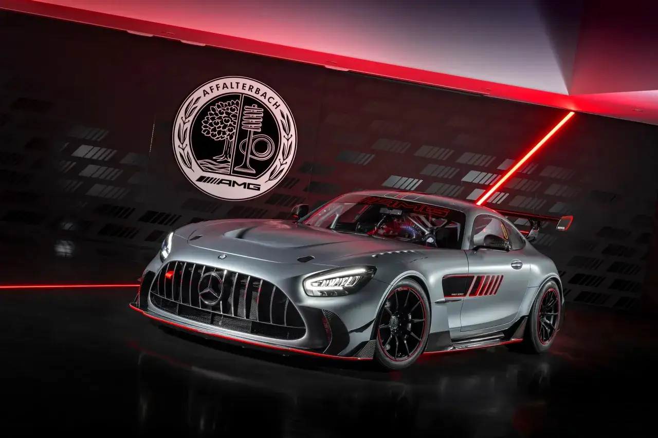 Srebrny Mercedes-AMG GT Black Series z czerwonymi akcentami, gotowy do wyścigu. W tle logo Affalterbach.