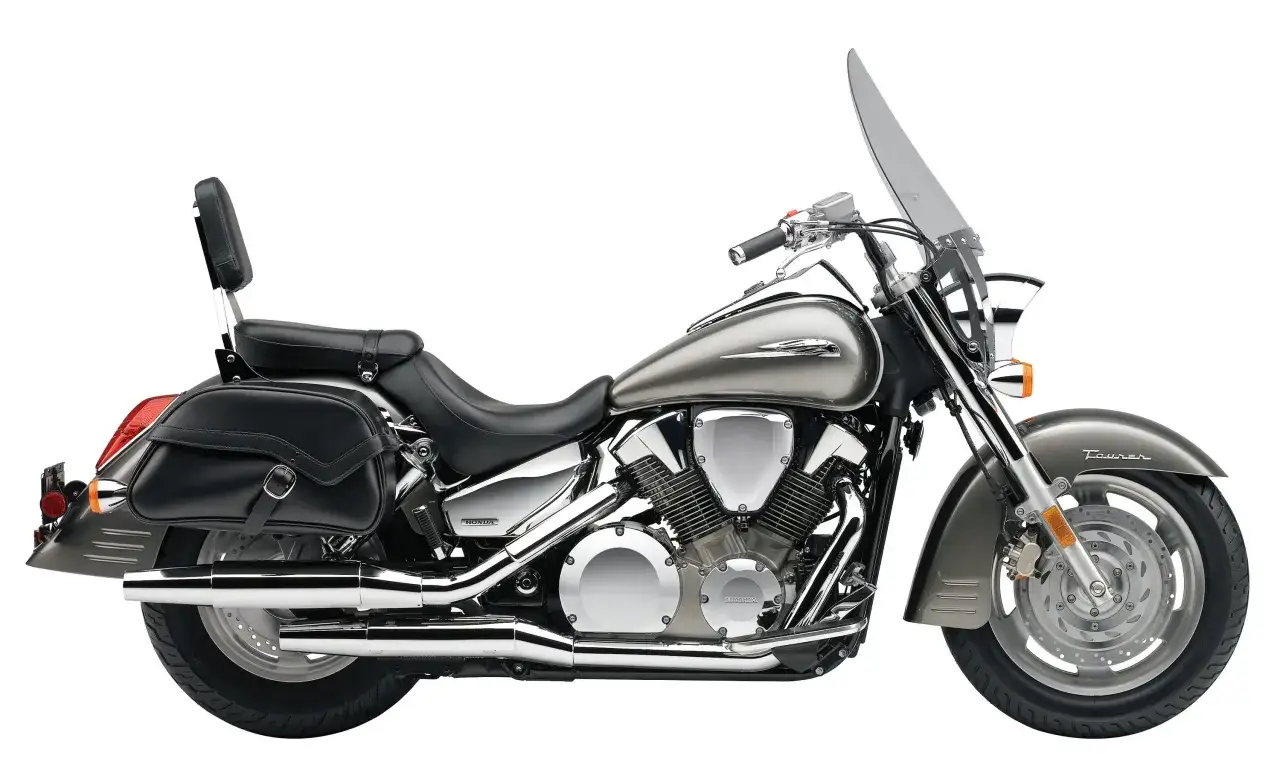 Srebrny motocykl Honda VTX 1300 z czarnymi sakwami i szybą.