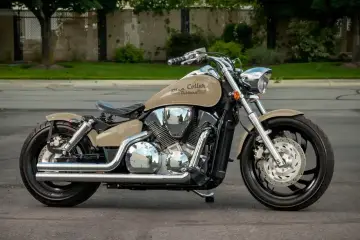 Beżowy motocykl Honda VTX 1300 z chromowanymi elementami i czarnym siedzeniem, zaparkowany na ulicy.