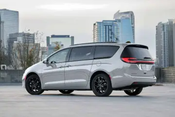 Srebrny Chrysler Pacifica z czarnymi felgami na tle miejskiej panoramy.