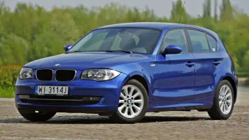 Niebieskie BMW E50, model z 2008 roku, stoi na brukowanej drodze.