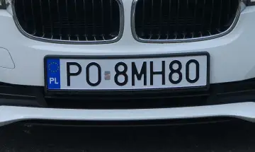 Biała tablica rejestracyjna PO 8MH80 z symbolem UE i PL.